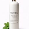 Aceite post depilatorio Koken con menta 500ml en botella blanca con tapón plateado sobre fondo blanco con hojas de menta fresca